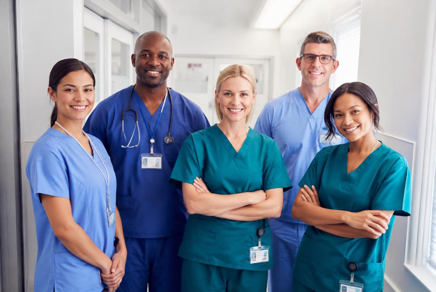 A team of nurses and care assistants standing together in a hospital corridor